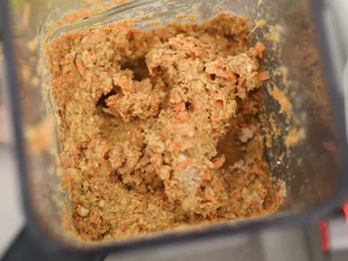 Blick in den Mixbehälter auf die fertig gemixte, orange-braune Karottenkuchen-Masse.