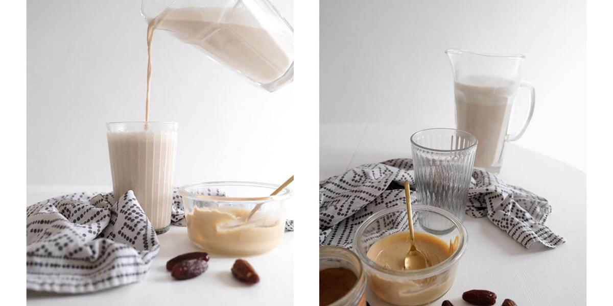 Cremige Haselnussmilch wird frisch aus einer Glaskaraffe in ein Glas gegossen